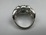a close up of a ring with a green stone in it