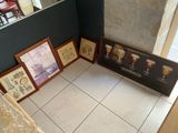 many framed pictures on the floor next to a mirror