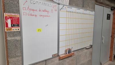 un tableau blanc accroché au mur à côté d'une porte