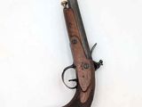 an old gun with a wooden handle on a white surface
