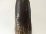 un vase marron avec un couvercle noir sur fond blanc
