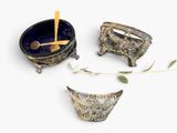 three bowls and spoons sitting on a white surface