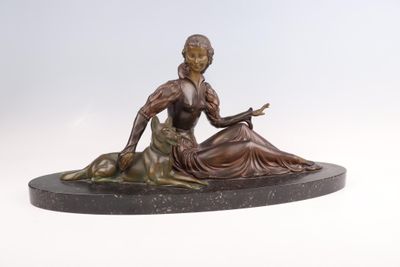 statue en bronze représentant une femme assise sur un rocher avec un chien