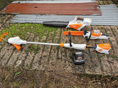 an orange and white string trimmer sitting on top of a wooden floor