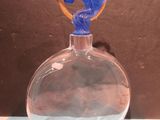 a glass vase with a blue bird on top of it