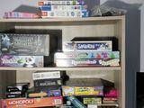 a bookcase filled with board games and other games