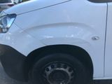 a white van parked in a parking lot with other cars in the background