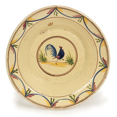 une assiette jaune sur laquelle est représenté un coq