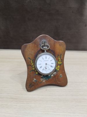 une petite horloge en bois ornée d'un motif floral