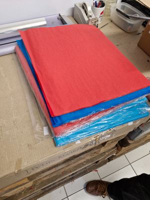 un homme debout à côté d'une table sur laquelle se trouvent des feuilles rouges et bleues