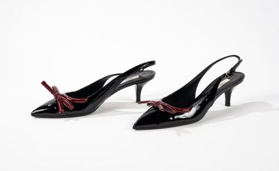 une paire de chaussures noires ornées de nœuds rouges sur le bout