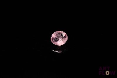 gros plan d'un diamant rose sur une surface noire