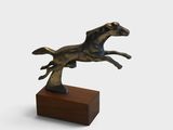 statue d'un cheval au galop posée sur un socle en bois, sur fond blanc
