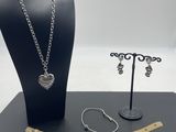 a black display case with a necklace, bracelet, and ring