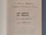 un livre ouvert posé sur une table, dont une page est écrite à la main