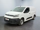 La camionnette blanche est garée dans une pièce au sol noir.