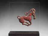 une image représentant un petit cheval en bronze posé sur un socle en bois