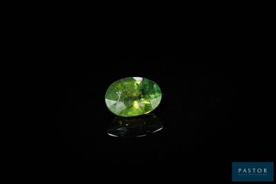 une tourmaline verte posée sur un fond noir