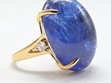 une bague en or jaune sertie d'une tanzanite ovale et de diamants
