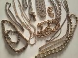 many different types of necklaces and bracelets laid out on a table