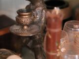 a small statue of a boy holding a bowl and a candle