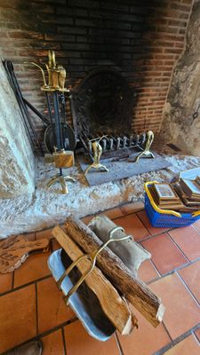 a fire place with a firewood and a bucket on the floor