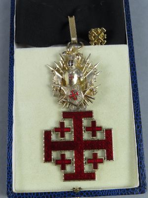 an image of a cross with a crown on it in a box