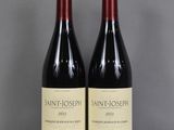 deux bouteilles de vin rouge sont posées côte à côte sur une table