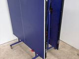 a blue ping pong table in the middle of a room