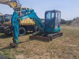 two excavators that are sitting in the grass