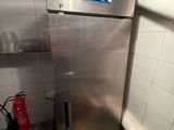 a stainless steel refrigerator in the corner of a kitchen