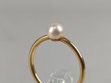 a close up of a gold ring with a pearl on top of it