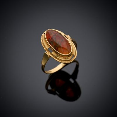 une bague en or avec une pierre rouge au centre