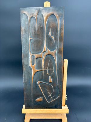 une sculpture en bronze représentant une femme assise sur un chevalet en bois