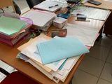 a desk with a computer and a lot of papers on it