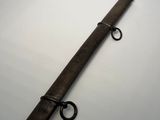 an old wooden sword with a metal handle on a white surface
