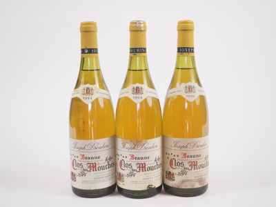trois bouteilles de vin posées les unes à côté des autres sur une surface blanche