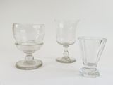 three glasses sitting next to each other on a white surface