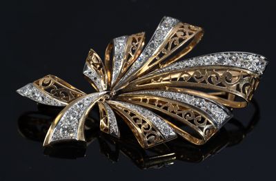 an image of a gold and diamond broochle on a black surface