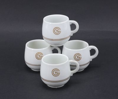 four white coffee mugs with a golden g on them