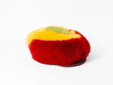 a red and yellow pom pom on a white surface
