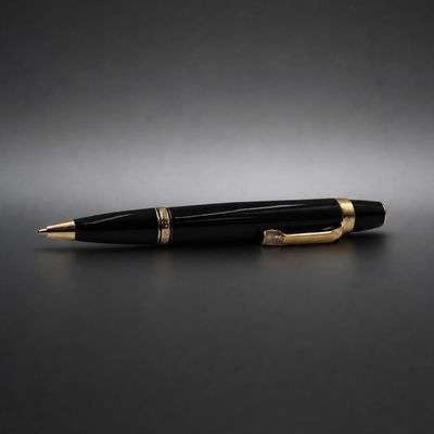 un stylo à bille noir et doré posé sur une surface noire
