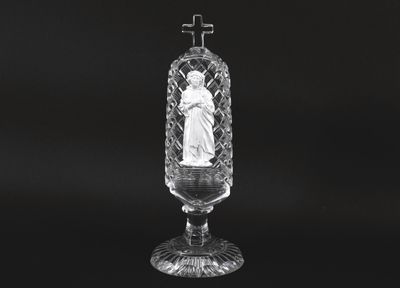 black and white photograph of a glass vase with a statue in it