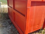 a red dumpster sitting in the middle of a field