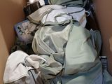 a pile of clothes in a cardboard box with a bottle of water