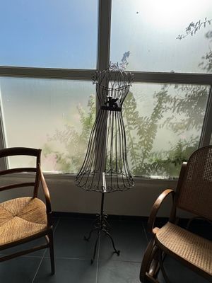 a chair and a mannequin in front of a window