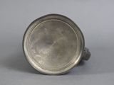 an old silver cup sitting on top of a gray surface