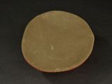 an image of a brown plate on a black surface