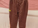 brown pants hanging on a clothes rack in front of a bed
