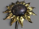 a metal sunflower on a stick on a gray surface